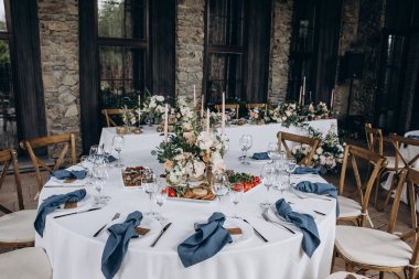 Düğün resepsiyonunda mumlar ve çiçeklerle güzel bir masa.                