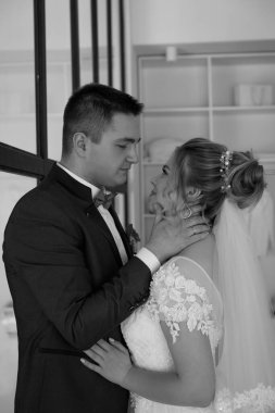 Gelin ve damat düğün gününde birbirlerine bakıyorlar, siyah ve beyaz.