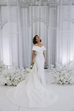 Zarif gelinlik içinde, elinde bir buket çiçekle güzel bir gelin.                      