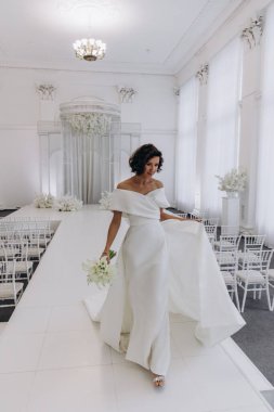 Zarif gelinlik içinde, elinde bir buket çiçekle güzel bir gelin.                      