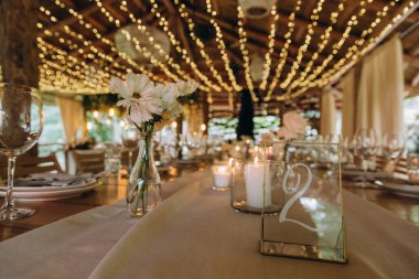 Düğün resepsiyonunda mumlar ve çiçeklerle güzel bir masa.                