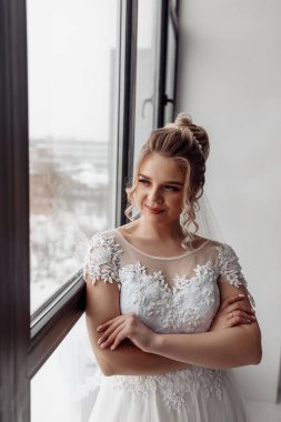 Gelinlikli güzel gelinin portresi pencereye bakıyor. 