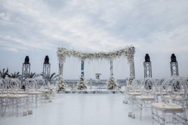 Sahilde çiçekler ve sandalyelerle güzel bir düğün töreni.