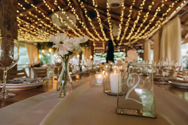 Düğün resepsiyonunda mumlar ve çiçeklerle güzel bir masa.                