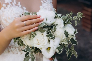 Güzel bir çiçek buketi tutan genç gelinin yakın plan görüntüsü..  