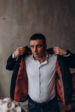 Gömlekli ve ceketli bir adam duvarın arkasında. 