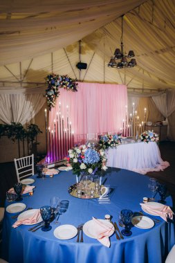 Düğün resepsiyonunda mumlar ve çiçeklerle güzel bir masa.                