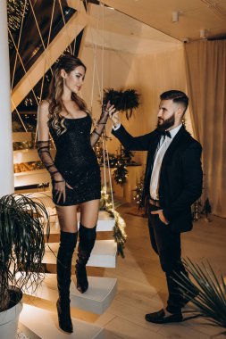 Merdivenlerde poz veren zarif bir çift. Bayanların elini tutan adam 