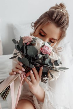 Zarif gelinlik içinde, elinde bir buket çiçekle güzel bir gelin.                      