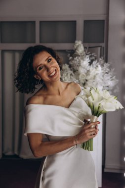 Zarif gelinlik içinde, elinde bir buket çiçekle güzel bir gelin.                      