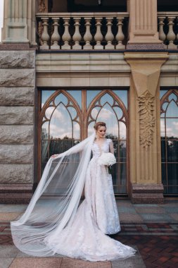 Zarif gelinlik içinde, elinde bir buket çiçekle güzel bir gelin.                      