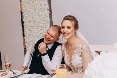 Genç ve mutlu bir çift restoranda gülüyor ve birlikte oturuyor.