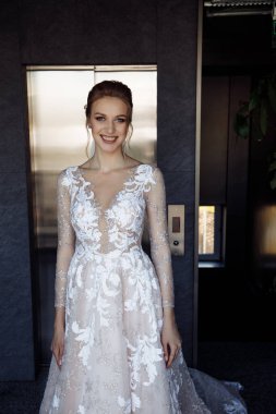 Gelinlik giymiş, kameraya gülümseyen çekici gelinin portresi.