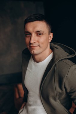 Karanlık bir stüdyoda genç ve çekici bir adamın portresi..