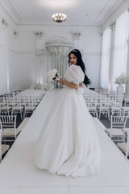 Zarif gelinlik içinde, elinde bir buket çiçekle güzel bir gelin.                      