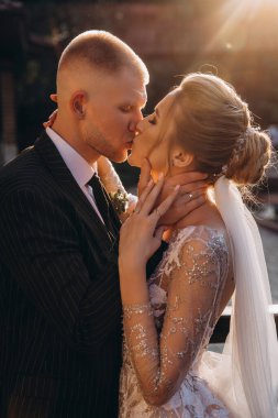 Gün batımında poz verip öpüşen genç ve güzel bir çift. gelin ve damat