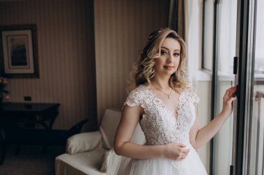 İçerde poz veren zarif gelinlik içinde güzel genç gelin.     