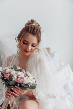 Zarif gelinlik içinde, elinde bir buket çiçekle güzel bir gelin.                      