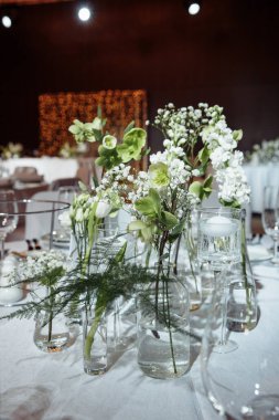 Düğün için çiçeklerle süslenmiş zarif bir masa seti ya da yemek servisi.                