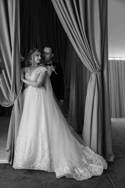 Gelin ve damadın portresi otel odasında poz veriyor.