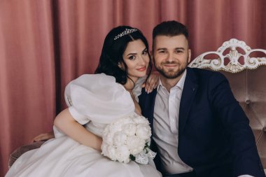 Mutlu gelin ve damat düğün günlerinde kanepede