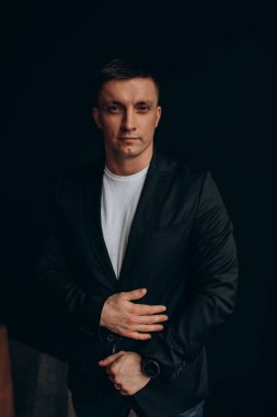 Stüdyoda siyah ceketli yakışıklı bir adam var..