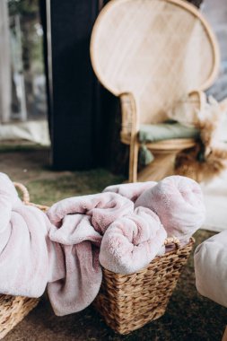 Hasır sepetlerde yumuşak battaniyeleri ve rahat mobilyaları olan rahat bir dekor.