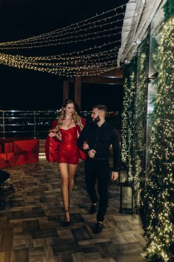 Kafede romantik genç bir çift. Kırmızı elbiseli bir adam.