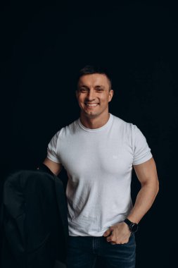 Stüdyoda beyaz gömlekli yakışıklı bir adamın portresi.