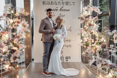 Genç mutlu gelin ve damat düğün töreninde poz veriyor.     