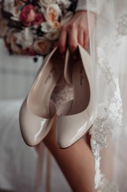 Gelin bacakları ve düğün ayakkabıları sabahları kanepede.