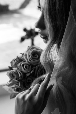 Genç, güzel bir gelin ve bir buket gül. Siyah beyaz. 