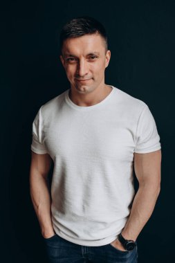 Siyah arka planda sıradan giyinmiş yakışıklı bir adam. 