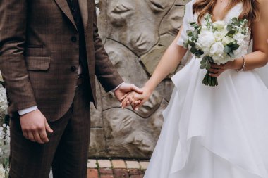 Düğün çifti parkta el ele tutuşurken çekilmiş..