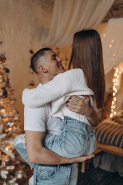 Noel ağacının yanında birbirine aşık bir çift stüdyoda poz veriyor. 