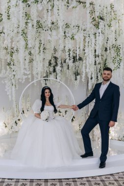 Güzel mutlu gelin ve damat stüdyoda poz veriyor.