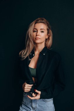 Güzel sarışın model stüdyoda kameraya poz veriyor.