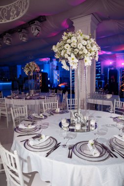Düğün resepsiyonunda çiçeklerle süslenmiş zarif bir masa.                 