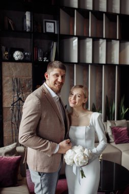 Genç gelin ve yakışıklı damat stüdyoda çiçeklerle