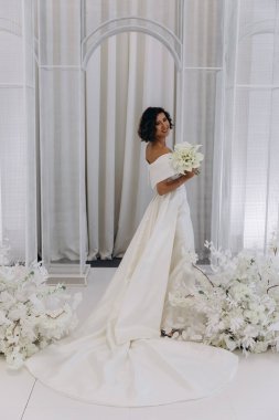 Çekici genç gelin elinde güzel bir düğün buketi tutuyor              