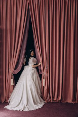 Stüdyoda poz veren beyaz gelinlik içindeki güzel gelinin portresi.