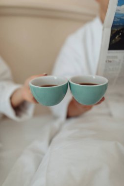 Yatakta kahvaltıda kahve içen çift. 