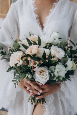 Çekici genç gelin elinde güzel bir düğün buketi tutuyor              