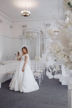 Lüks düğün salonunda beyaz elbiseli güzel bir gelin.           
