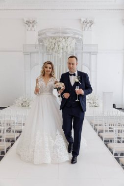 Gelin ve damat düğün töreninde şampanya kadehleri tutuyorlar.