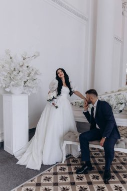 Güzel gelinin elini öpen yakışıklı genç damat.