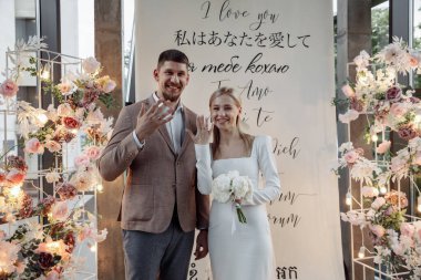 Genç aşıkların portresi. Törende alyansları gösteriyor.