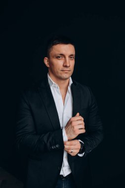 Beyaz gömlekli ve siyah ceketli genç bir adam.