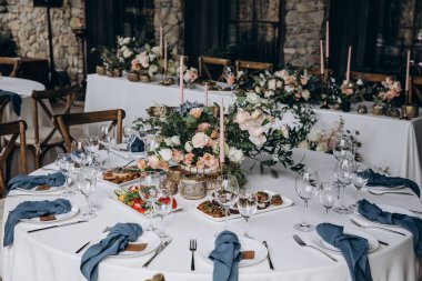 Düğün resepsiyonunda mumlar ve çiçeklerle güzel bir masa.                           