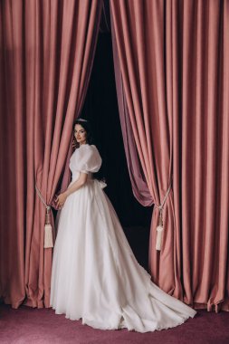 Stüdyoda poz veren beyaz gelinlik içindeki güzel gelinin portresi.